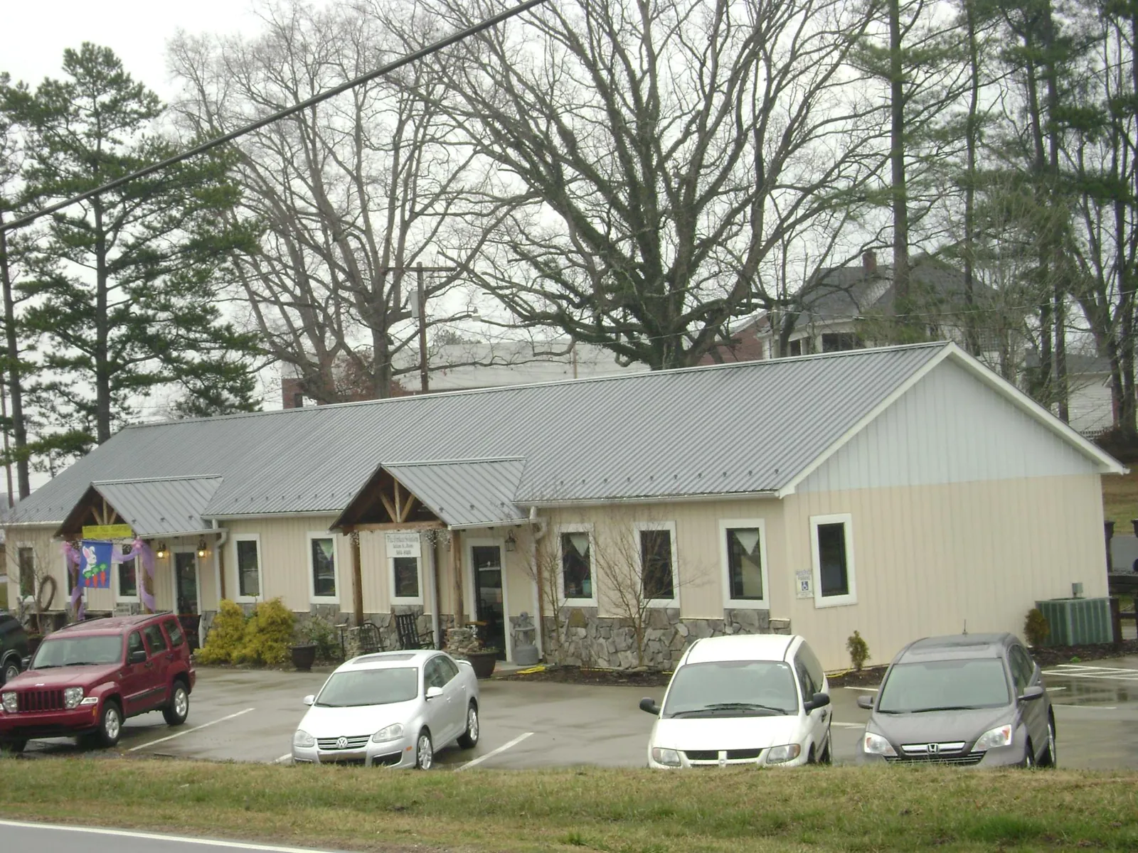 Gray metal roof with timber entry brackets on a small commercial building in Hollywood