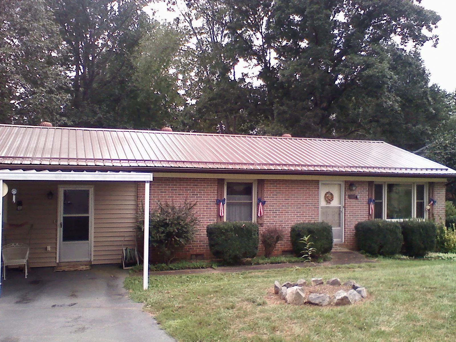 Bronze metal roof and carport on a brick ranch home — Roof Repair work by our crew in Hollywood